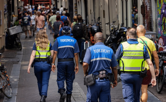Team van handhaving en toezicht loopt door een drukke winkelstraat