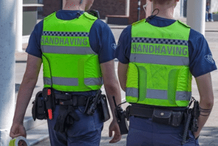 Twee handhavers lopen samen over straat